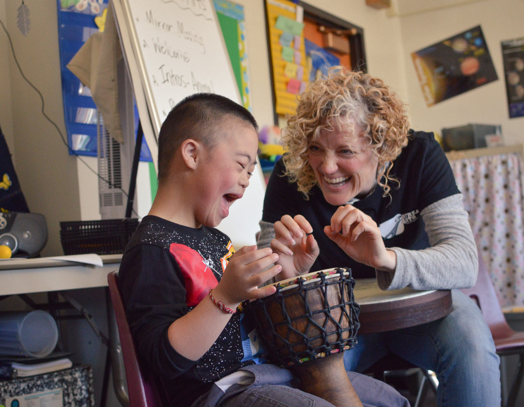 Upstream Arts participant and teaching artist drumming